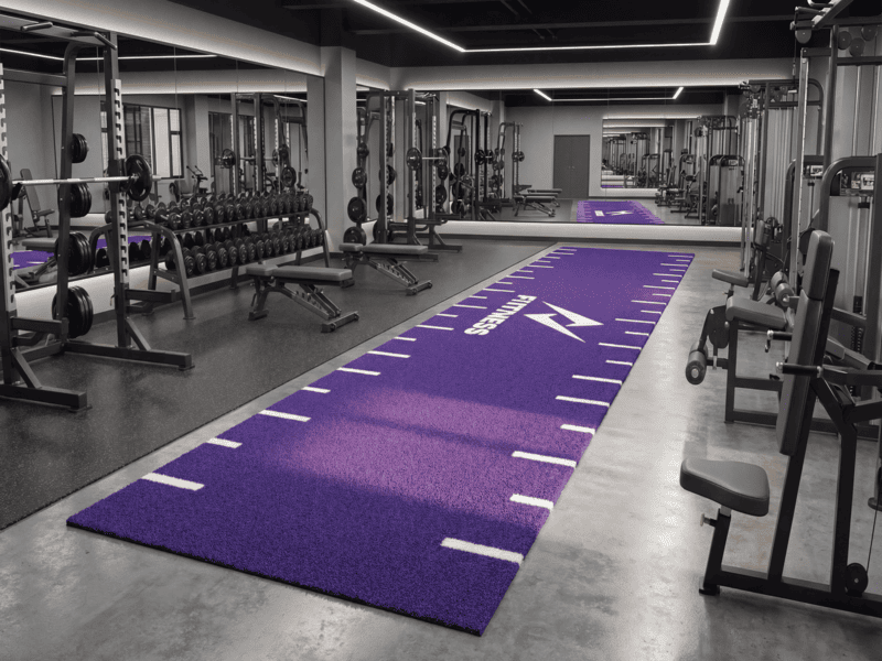 Athlete pushing a sled on high-performance gym turf